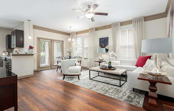 A living room with a white couch, a coffee table, and a ceiling fan.