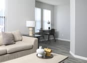 Thumbnail 4 of 5 - a living room with a couch and a table with a desk