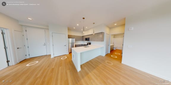 a view of a kitchen and a living room with wood flooring