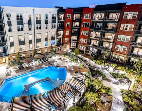 A large swimming pool in the middle of a courtyard surrounded by apartment buildings.
