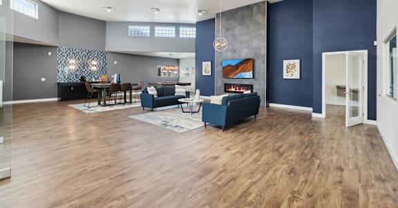 A modern living room with a dark blue accent wall and a fireplace.
