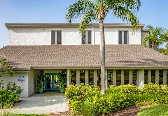 a house with palm trees in front of it at L'Estancia, Sarasota, FL