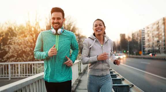 a man and a woman running on a city street