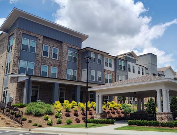 A large, modern building with a landscaped front yard.