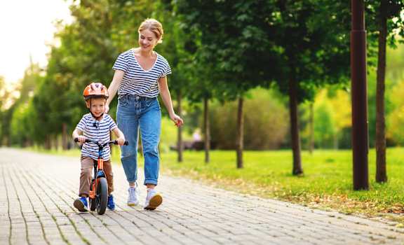 Woman and a young boy riding a bike down a path at Mainstreet Apartments, Clearwater, Florida 33756