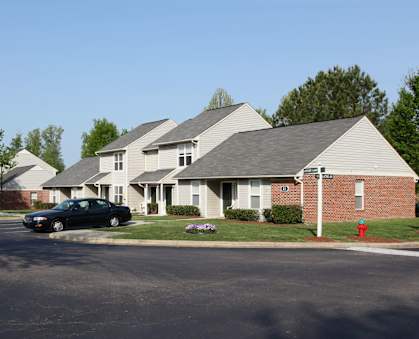 A black car is parked in front of a house.