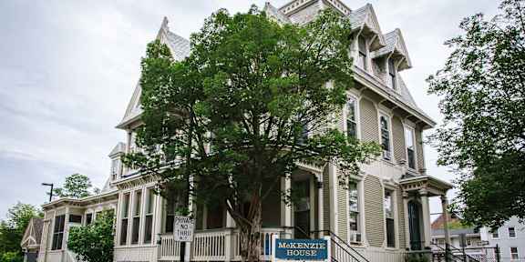 a large white house with a tree in front of it