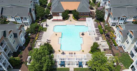 aerial view of Fenwyck Manor's large pool and sundeck, landscaping, and residential buildings
