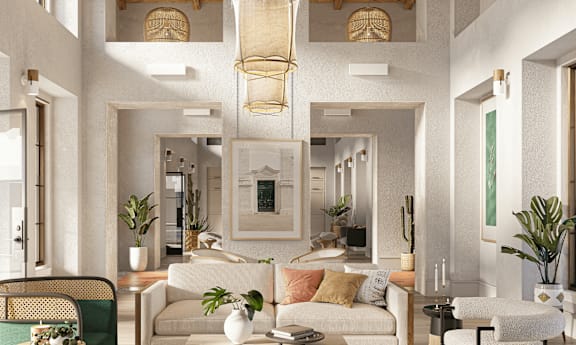 A living room with a white sofa and a green waste basket.