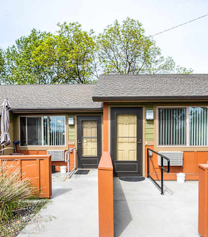 A row of houses with orange fences and green roofs.