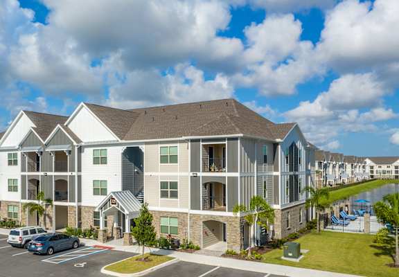 A large apartment complex with a parking lot in front at Mode at Melbourne, LLC Apartments, Florida, 32901