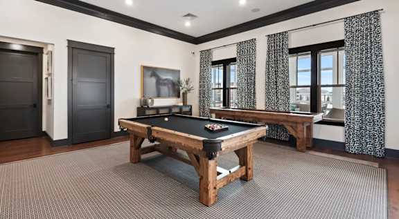 A pool table in a room with a black door and patterned curtains. at The Lofts at Town Madison, Madison, AL