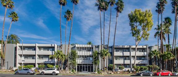 a group of tall palm trees in front of an apartment building at Candlewood North, Northridge, California