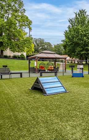 A playground with a slide, a swing set, and a fire hydrant.