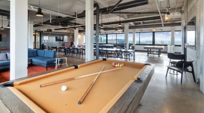 a pool table in a room with tables and chairs