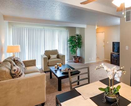A living room with a couch, chair, and dining table.