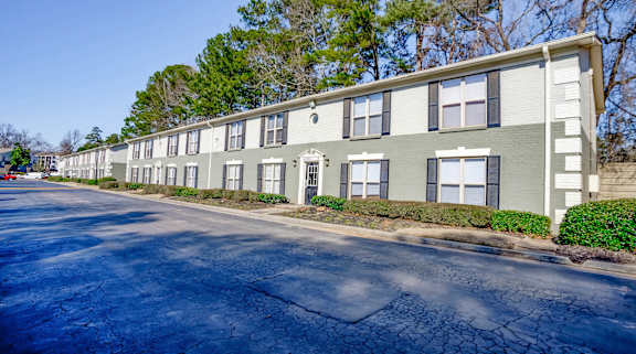 A long building with a green and white exterior.