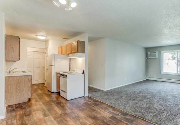 A kitchen with white appliances and wooden cabinets.