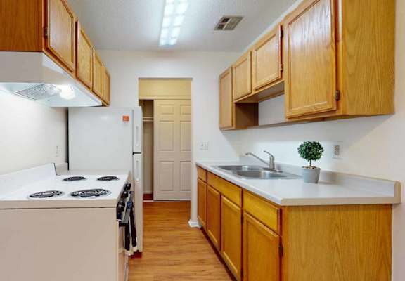 A kitchen with wooden cabinets and a white counter top.