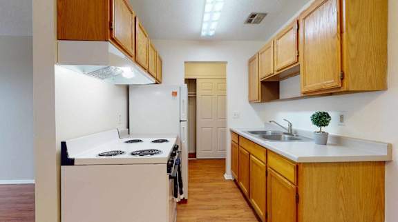 A kitchen with wooden cabinets and a white counter top.