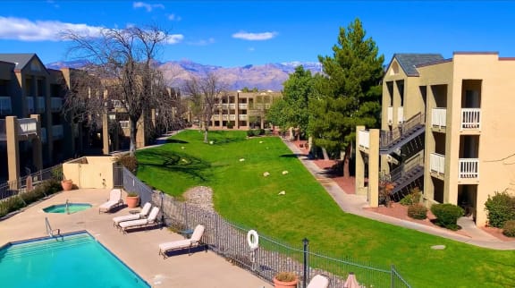 an aerial view of a yard with a pool and apartment buildings