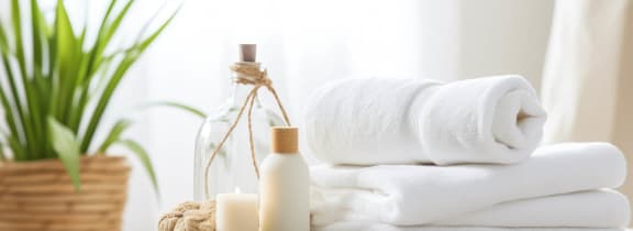 a pile of towels and a bottle of soap on a table