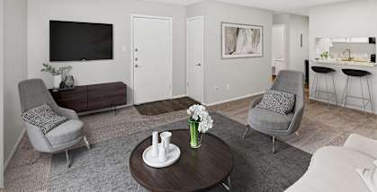 Model apartment living room with a couch and chairs and a table