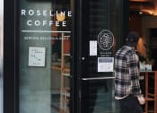 Thumbnail 12 of 14 - Man Walking into Roseline Coffee Shop