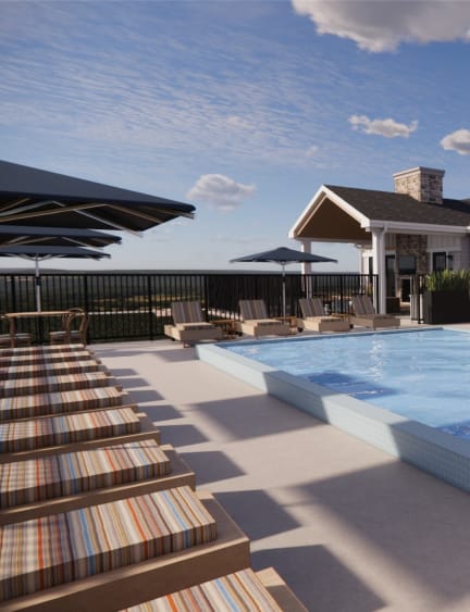 A large swimming pool with a white building in the background. at Sandhill Parkway Townhomes Apartments, East Bethel, Minnesota