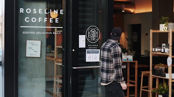 Man Walking into Roseline Coffee Shop