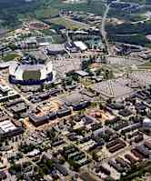 An aerial view of a city with a large stadium in the center.