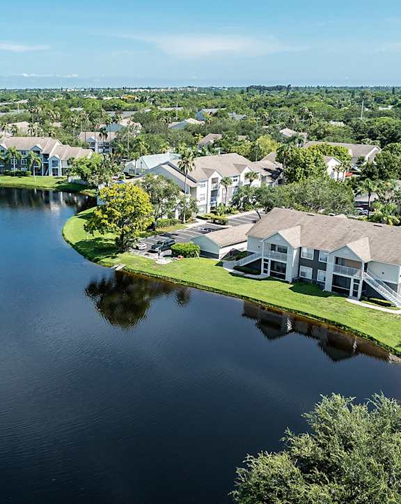 an aerial view of a pond with a fountain in the middle of it and houses