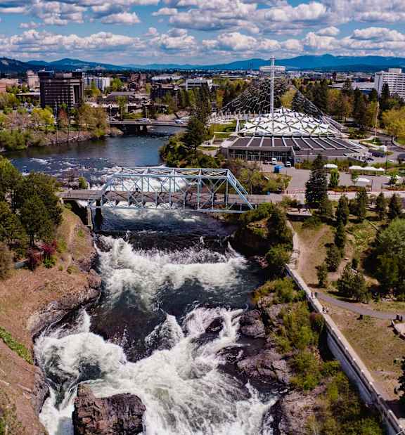 A river flows through a city with a bridge and a dam.