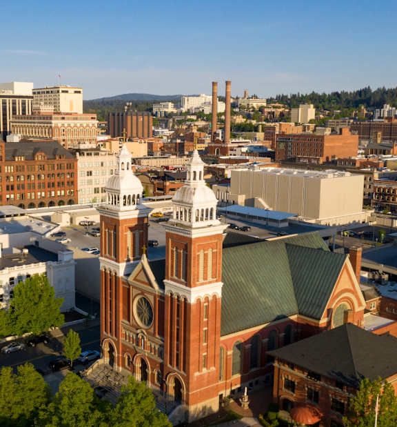 A cityscape with a prominent church featuring a green roof and a white dome.