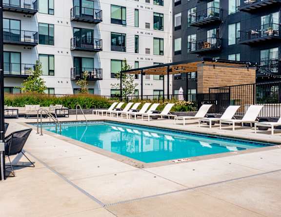 a patio with a grill and a bar with stools