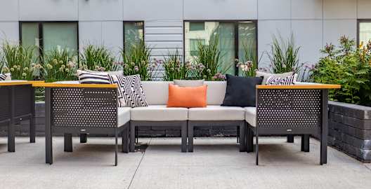 an outdoor seating area with rattan furniture and a table and chairs