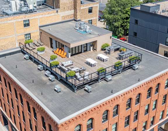 an aerial view of a brick building with a rooftop deck
