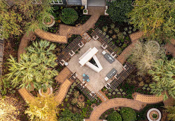 a birds eye view of a garden with a pavilion and trees