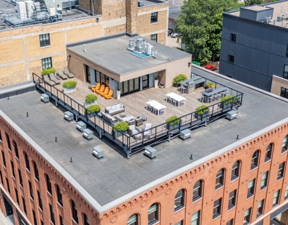an aerial view of a brick building with a rooftop deck