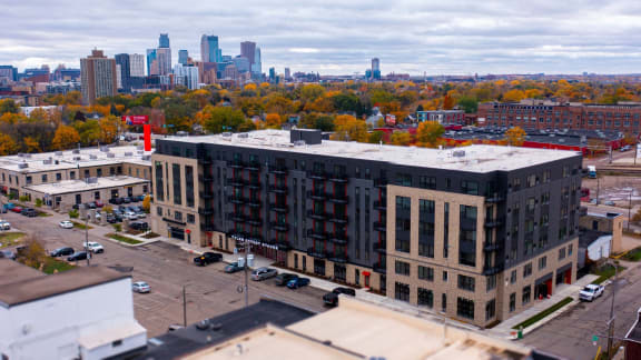 an aerial view of an apartment building with a city skyline in the background