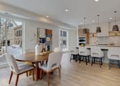 Thumbnail 34 of 51 - A modern kitchen with a dining table and chairs.