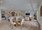Thumbnail 32 of 51 - A modern kitchen with a dining table and chairs.