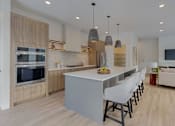 Thumbnail 33 of 51 - A modern kitchen with a large island and a TV mounted on the wall.