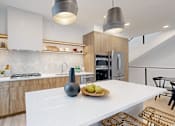 Thumbnail 50 of 51 - A modern kitchen with a white island and wooden cabinets.