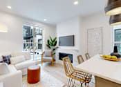 Thumbnail 48 of 51 - A modern living room with a white sofa, a wooden coffee table, and a TV mounted on the wall.