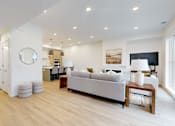 Thumbnail 41 of 51 - A modern living room with a grey sofa and wooden floors.