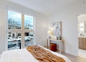 Thumbnail 43 of 51 - A bedroom with a large bed and a view of the street outside.