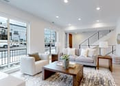Thumbnail 46 of 51 - A living room with a couch, armchair, and coffee table.