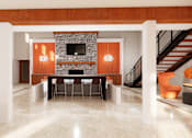 Thumbnail 10 of 13 - A modern living room with a stone fireplace and a staircase.