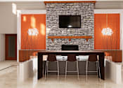 Thumbnail 9 of 13 - A modern living room with a stone fireplace and a TV above it.